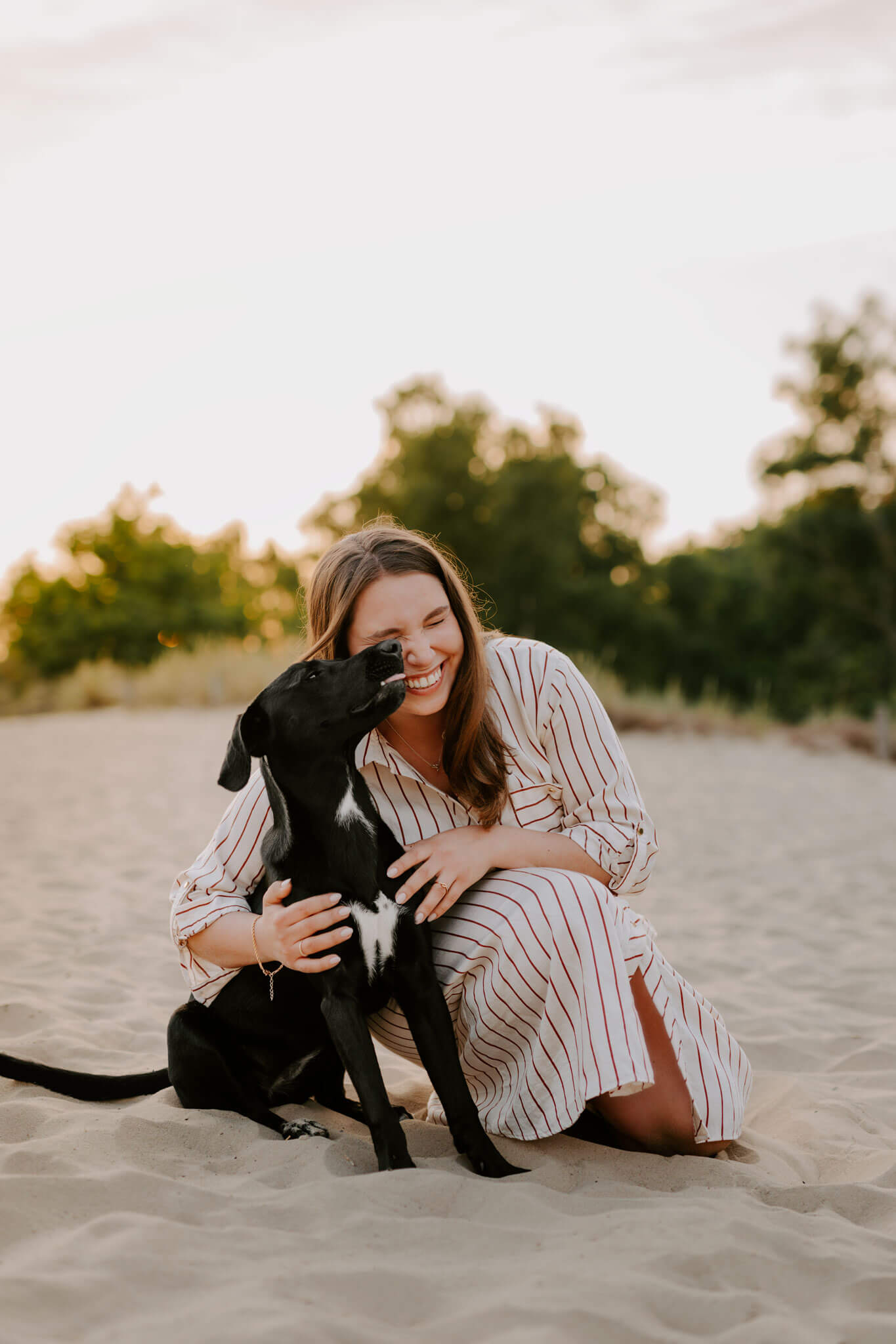 schwarzer hund mit Frauchen bei fotoshooting im Sand in Hamburg fotoshooting