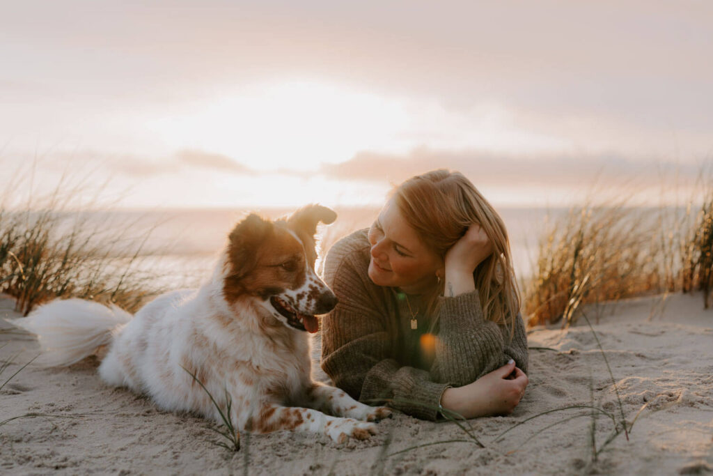 hund und Besitzerin am Strand bei einem fotoshooting im Wasser