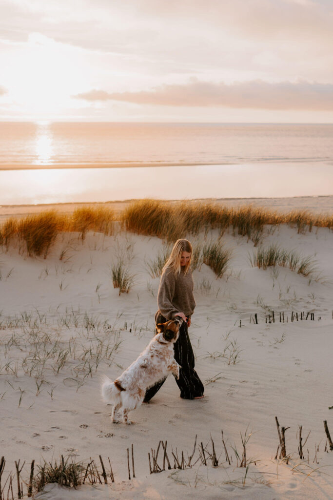 hund und Besitzerin am Strand bei einem fotoshooting im Wasser
