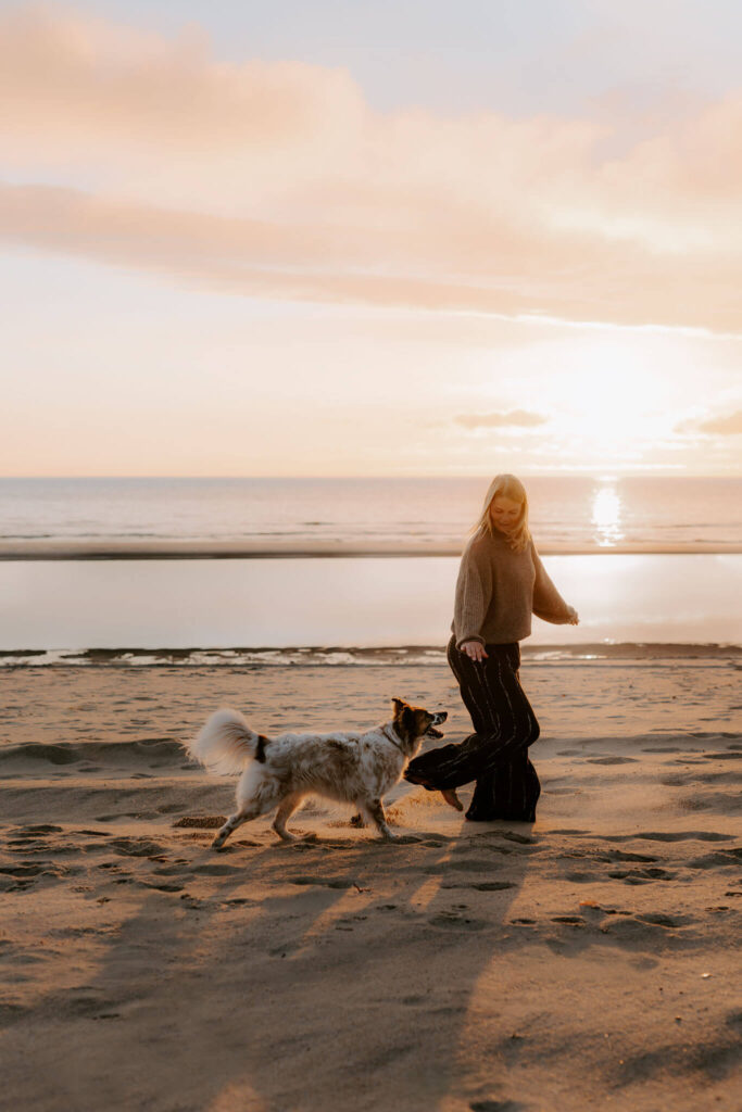 hund und Besitzerin am Strand bei einem fotoshooting im Wasser