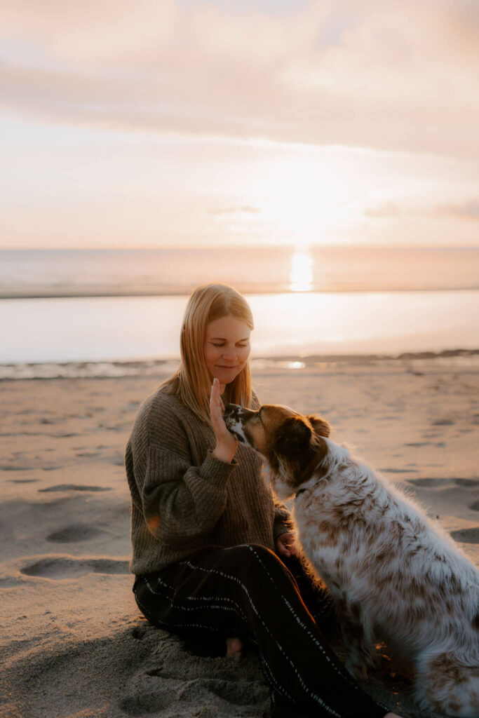 hund und Besitzerin am Strand bei einem fotoshooting im Wasser