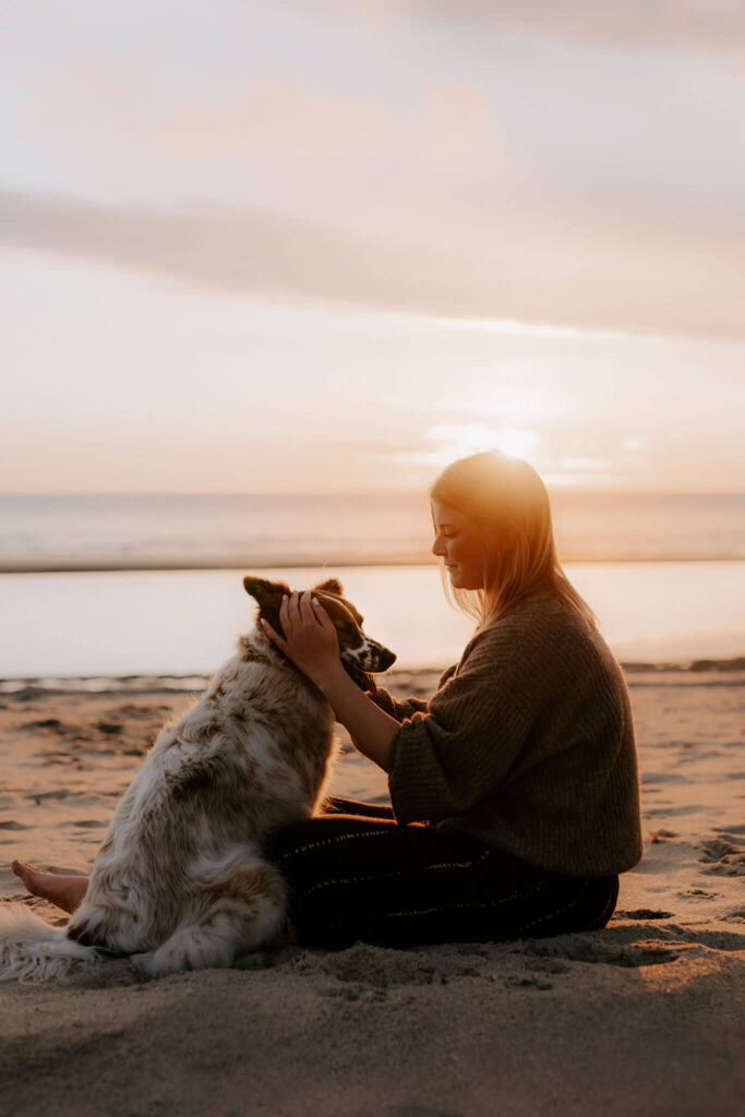 hund und Besitzerin am Strand bei einem fotoshooting im Wasser